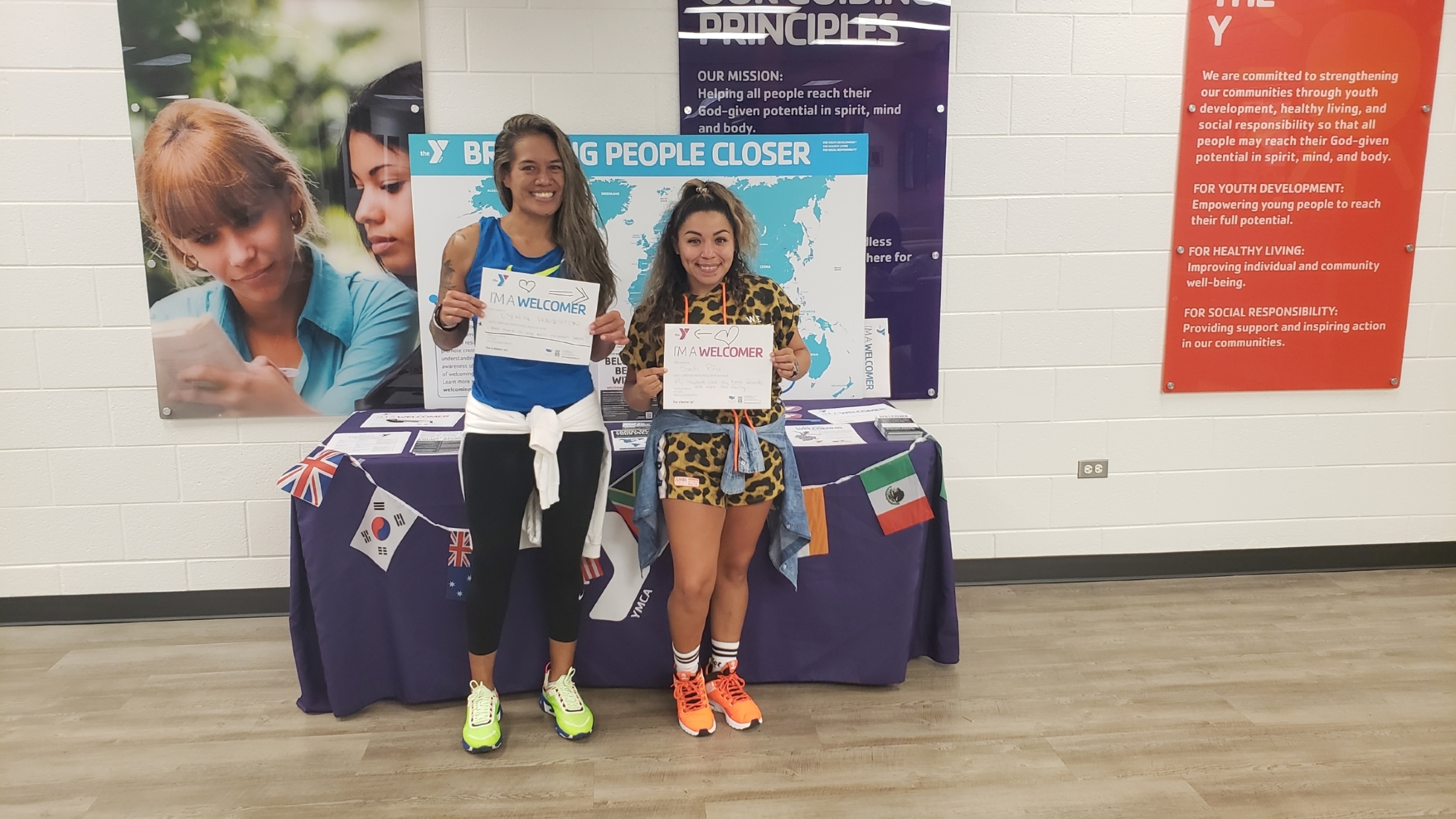 Two people with I'm a Welcomer signs