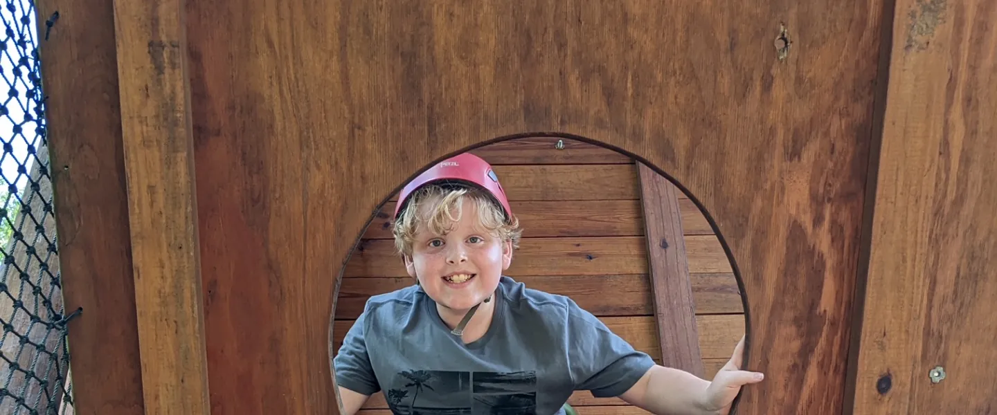 Boy in climbing wall hole