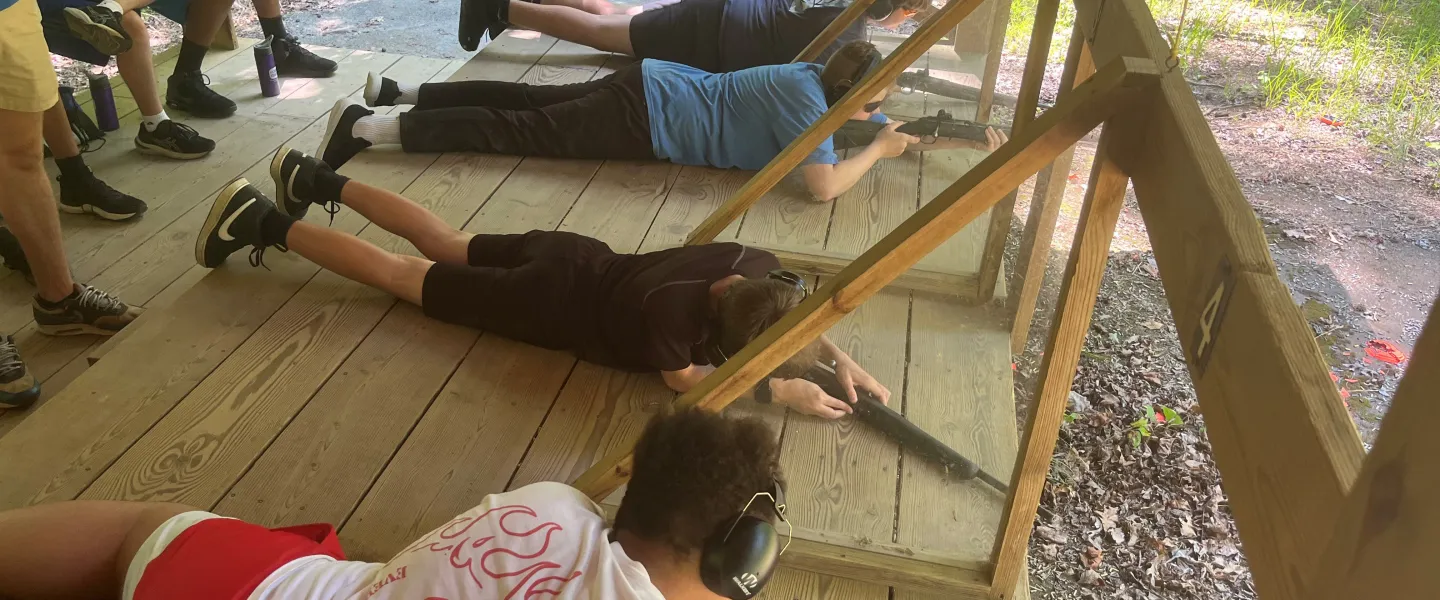 Boys shooting rifles prone